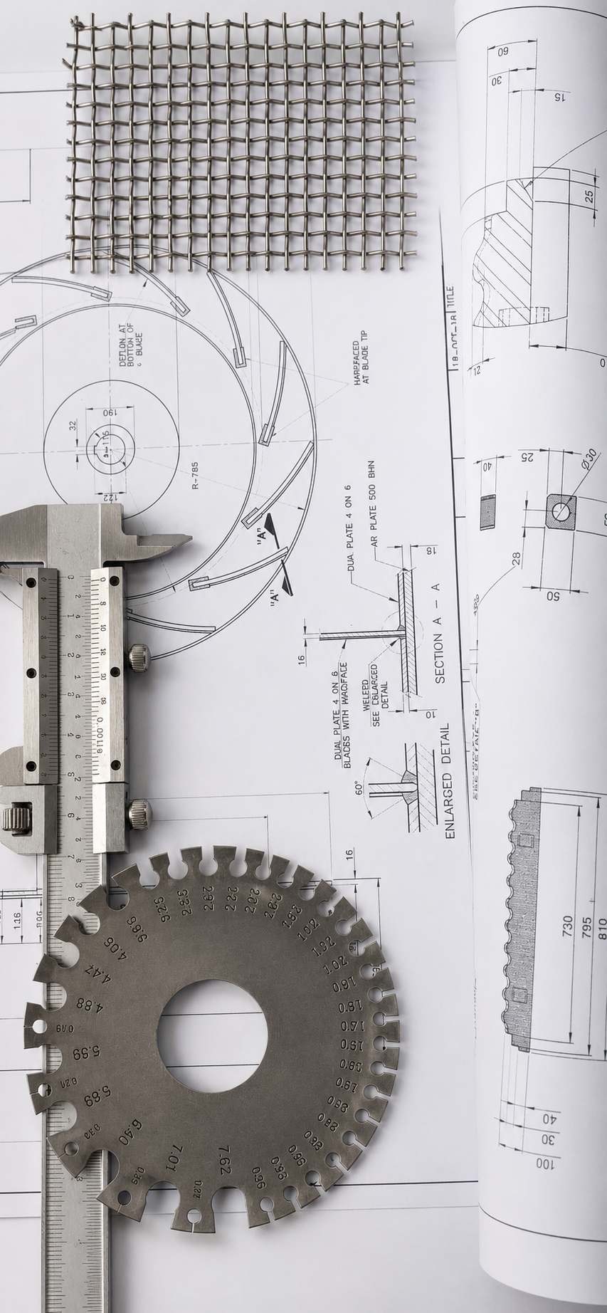 Caliper, gear gauge and wire mesh on technical drawings for dimensional inspection